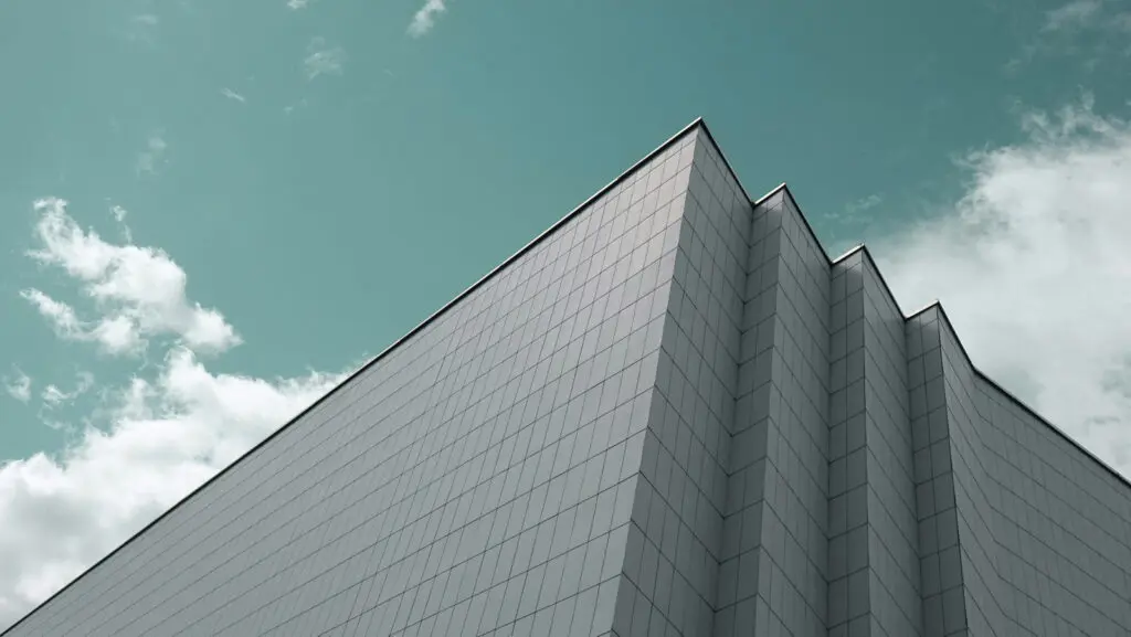Looking up at the corner of a large corporate clean building.